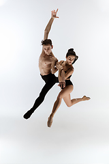 Image showing Two graceful ballet dancers man and woman in minimal black style dancing isolated on white studio background