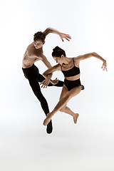 Image showing Young and graceful ballet dancers in minimal black style isolated on white studio background