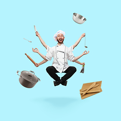 Image showing Happy handsome multi-armed cooker levitating isolated on blue studio background with equipment