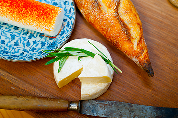 Image showing French cheese and fresh  baguette on a wood cutter