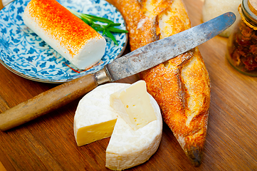 Image showing French cheese and fresh  baguette on a wood cutter