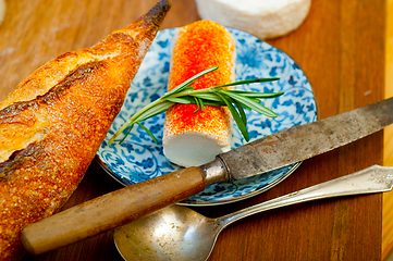 Image showing French cheese and fresh  baguette on a wood cutter