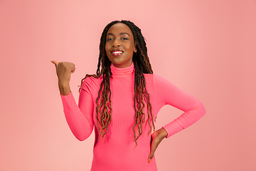 Image showing Portrait of young african-american woman isolated on pink studio background, facial expression. Beautiful female half-lenght portrait with copyspace.