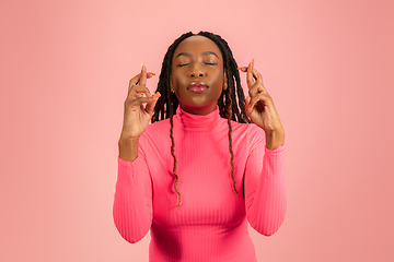 Image showing Young emotional african-american woman isolated on pink studio background, facial expression. Half-lenght portrait with copyspace.