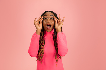 Image showing Young emotional african-american woman isolated on pink studio background, facial expression. Half-lenght portrait with copyspace.