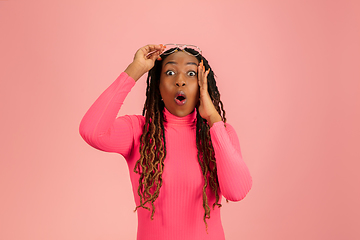 Image showing Young emotional african-american woman isolated on pink studio background, facial expression. Half-lenght portrait with copyspace.