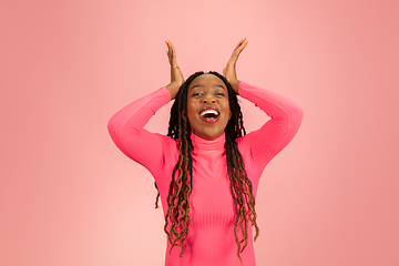 Image showing Happy emotional african-american woman isolated on pink studio background, facial expression. Half-lenght portrait with copyspace.