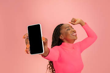 Image showing Portrait of happy african-american woman isolated on pink studio background, facial expression. Half-lenght portrait with copyspace.