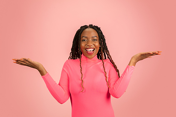 Image showing Happy emotional african-american woman isolated on pink studio background, facial expression. Half-lenght portrait with copyspace.