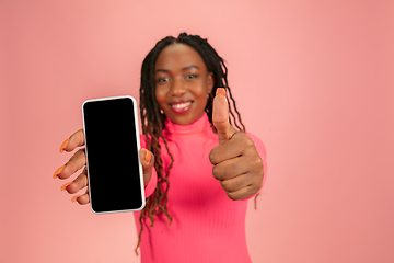 Image showing Portrait of happy african-american woman isolated on pink studio background, facial expression. Half-lenght portrait with copyspace.