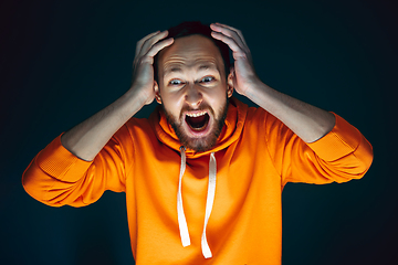 Image showing Close up portrait of crazy scared and shocked man isolated on dark background