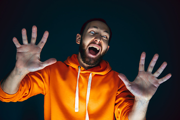 Image showing Close up portrait of crazy scared and shocked man isolated on dark background