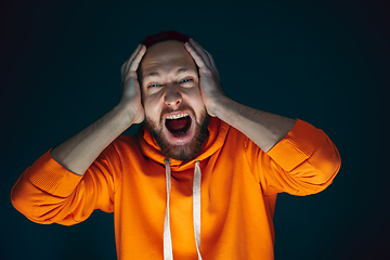 Image showing Close up portrait of crazy scared and shocked man isolated on dark background