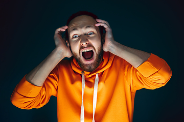 Image showing Close up portrait of crazy scared and shocked man isolated on dark background