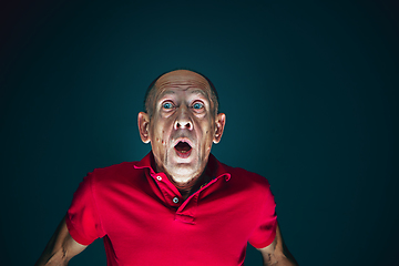 Image showing Close up portrait of crazy scared and shocked man isolated on dark background