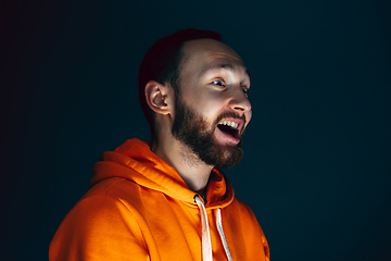 Image showing Close up portrait of crazy scared and shocked man isolated on dark background