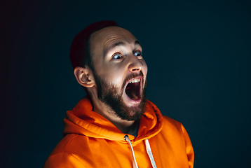 Image showing Close up portrait of crazy scared and shocked man isolated on dark background