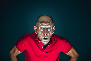 Image showing Close up portrait of crazy scared and shocked man isolated on dark background