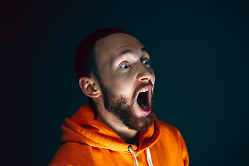 Image showing Close up portrait of crazy scared and shocked man isolated on dark background