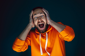 Image showing Close up portrait of crazy scared and shocked man isolated on dark background