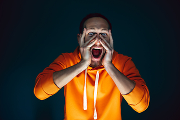 Image showing Close up portrait of crazy scared and shocked man isolated on dark background