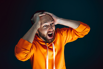 Image showing Close up portrait of crazy scared and shocked man isolated on dark background
