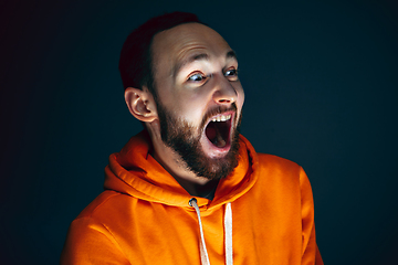 Image showing Close up portrait of crazy scared and shocked man isolated on dark background