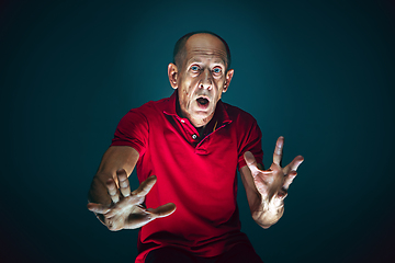 Image showing Close up portrait of crazy scared and shocked man isolated on dark background