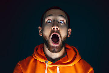 Image showing Close up portrait of crazy scared and shocked man isolated on dark background