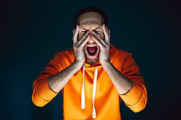 Image showing Close up portrait of crazy scared and shocked man isolated on dark background