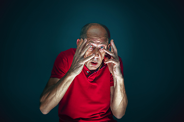 Image showing Close up portrait of crazy scared and shocked man isolated on dark background