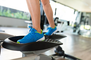 Image showing Woman doing exercises in the gym on elliptical cross trainer