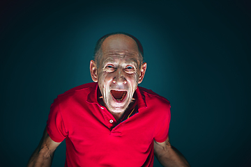 Image showing Close up portrait of crazy scared and shocked man isolated on dark background