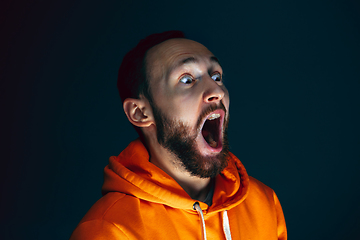 Image showing Close up portrait of crazy scared and shocked man isolated on dark background