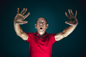 Image showing Close up portrait of crazy scared and shocked man isolated on dark background