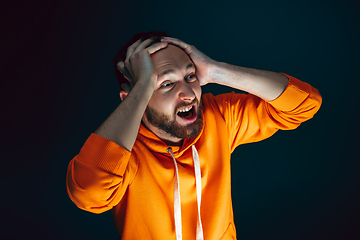 Image showing Close up portrait of crazy scared and shocked man isolated on dark background