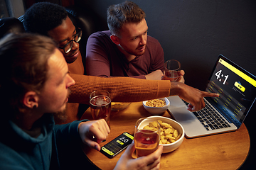 Image showing Excited fans with mobile app for betting and score on their devices. Gambling, emotions