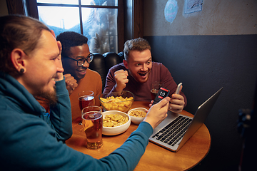 Image showing Excited fans with mobile app for betting and score on their devices. Gambling, emotions