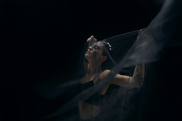 Image showing Graceful classic female ballet dancer isolated on black studio background. The grace, artist, movement, action and motion concept.