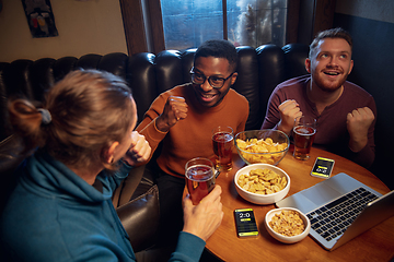 Image showing Excited fans with mobile app for betting and score on their devices. Gambling, emotions