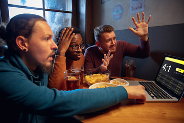 Image showing Excited fans with mobile app for betting and score on their devices. Gambling, emotions