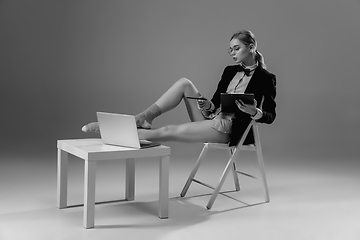 Image showing Young fashionable, stylish woman wearing jacket and socks working from home. Fashion during insulation \'cause of coronavirus pandemic