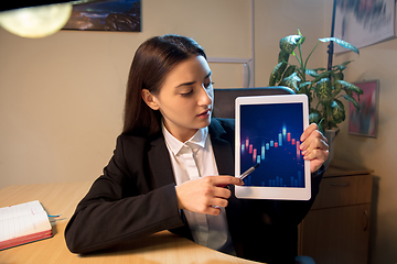 Image showing Young woman talking, working during videoconference with colleagues at home