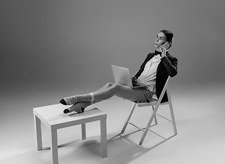 Image showing Young fashionable, stylish woman wearing jacket and socks working from home. Fashion during insulation \'cause of coronavirus pandemic