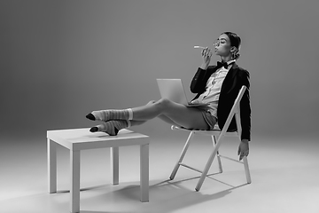 Image showing Young fashionable, stylish woman wearing jacket and socks working from home. Fashion during insulation \'cause of coronavirus pandemic