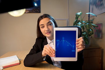 Image showing Young woman talking, working during videoconference with colleagues at home