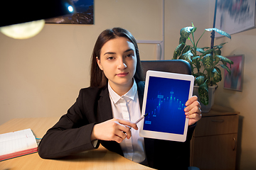 Image showing Young woman talking, working during videoconference with colleagues at home