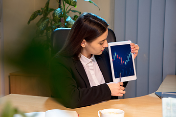 Image showing Young woman talking, working during videoconference with colleagues at home