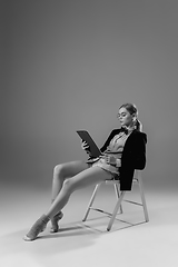 Image showing Young fashionable, stylish woman wearing jacket and socks working from home. Fashion during insulation \'cause of coronavirus pandemic