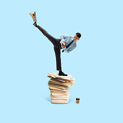 Image showing Office worker, businessman, sportsman fighting with deadlines standing on the bunch of documents